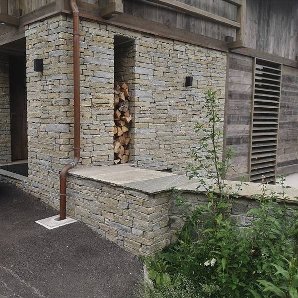 rangement bois et mur en pierre
